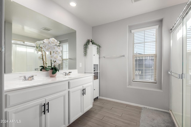 bathroom featuring baseboards, wood tiled floor, visible vents, and a sink