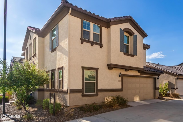 view of property exterior with a garage, concrete driveway, and stucco siding