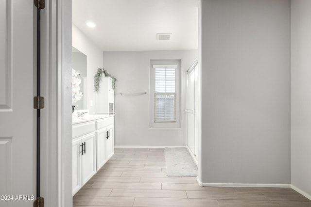 bathroom with wood tiled floor, visible vents, vanity, and baseboards