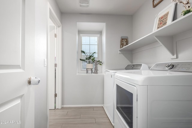 laundry area featuring laundry area, wood finish floors, visible vents, baseboards, and washing machine and clothes dryer