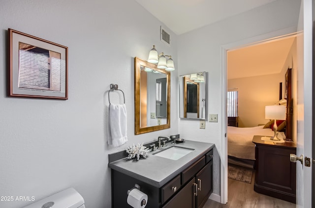 bathroom featuring vanity, hardwood / wood-style floors, and toilet