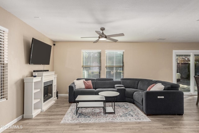 living room featuring wood-type flooring, plenty of natural light, and ceiling fan