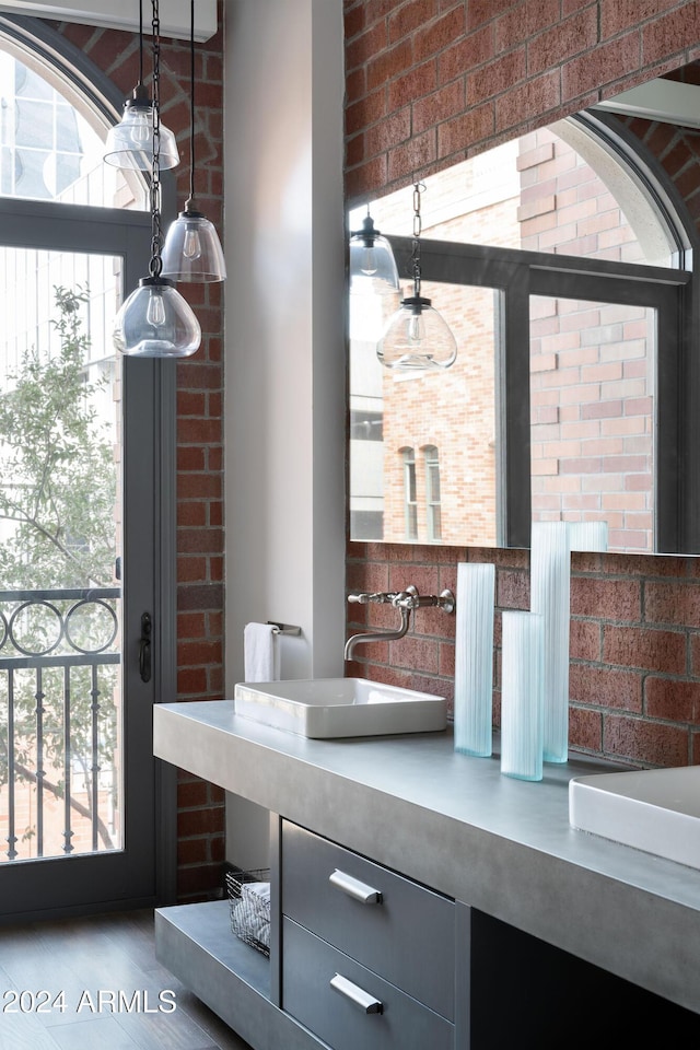 interior space featuring vanity and brick wall