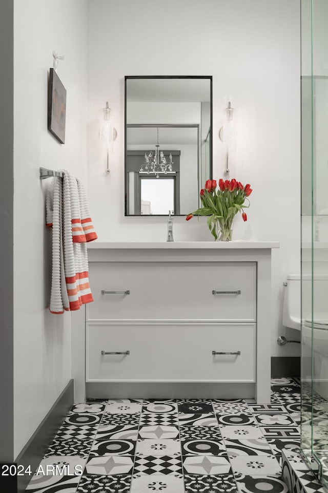 bathroom featuring vanity, a chandelier, and toilet