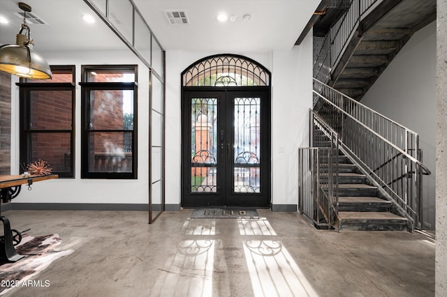 entrance foyer with concrete flooring and french doors