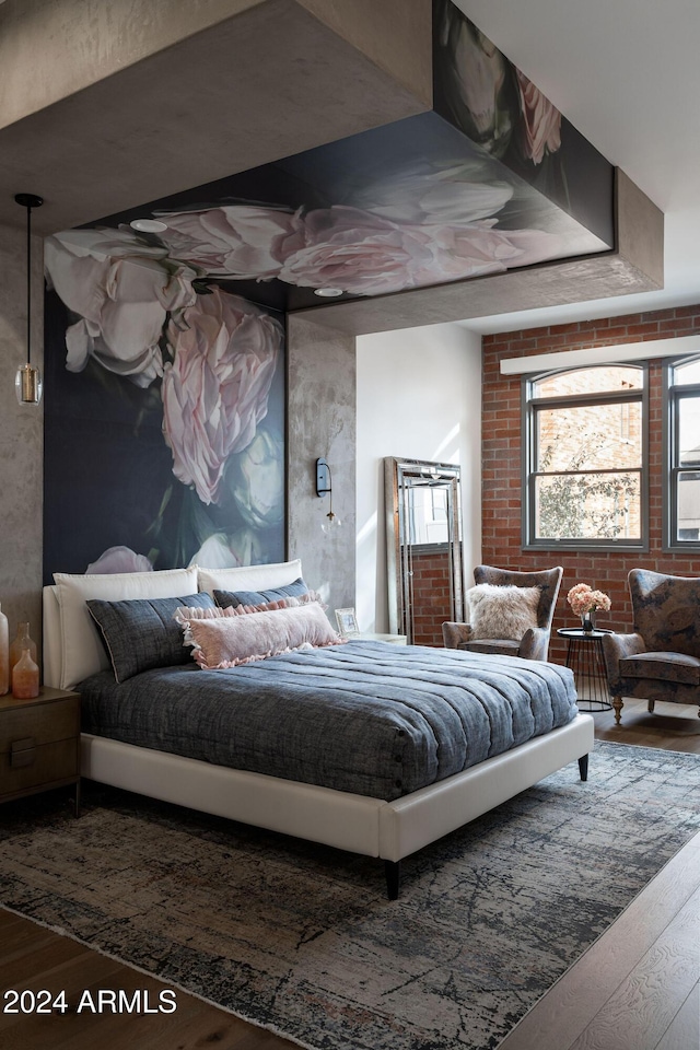 bedroom with hardwood / wood-style floors and brick wall