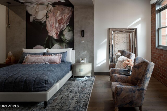 bedroom featuring dark hardwood / wood-style flooring and brick wall