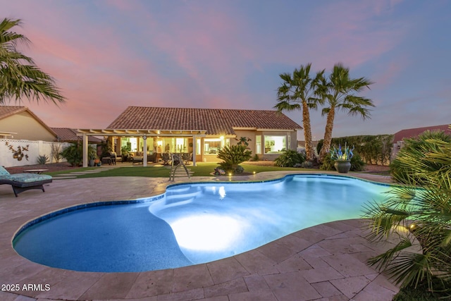 pool at dusk with a patio area