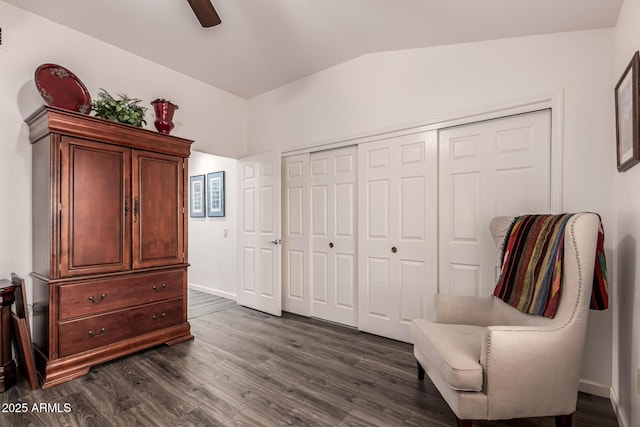 living area featuring lofted ceiling, dark wood-type flooring, and ceiling fan