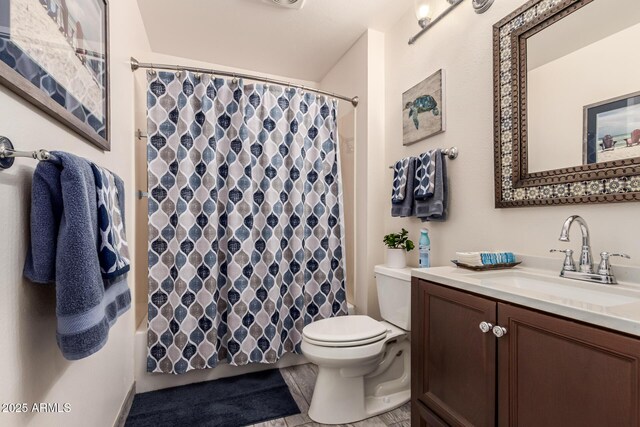 bathroom featuring vanity, toilet, and walk in shower