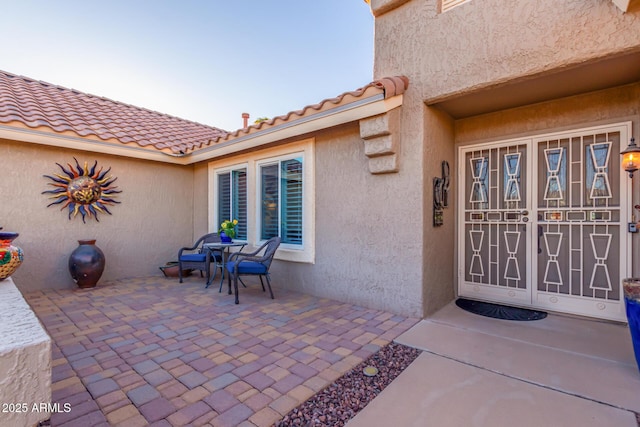 view of exterior entry featuring a patio area