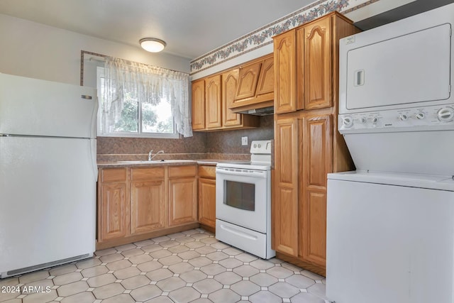 kitchen with decorative backsplash, sink, white appliances, and stacked washer and dryer