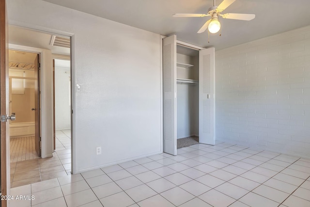 unfurnished bedroom featuring light tile patterned floors, a closet, and ceiling fan