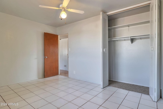 unfurnished bedroom with ceiling fan, a closet, and light tile patterned floors