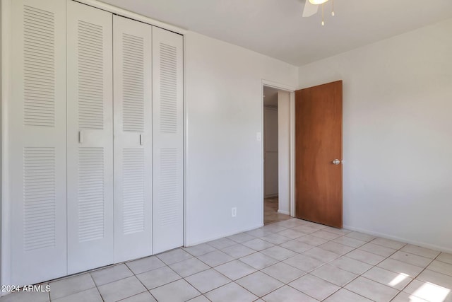 unfurnished bedroom with ceiling fan, a closet, and light tile patterned floors