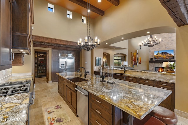 kitchen with a sink, arched walkways, stainless steel appliances, and a chandelier