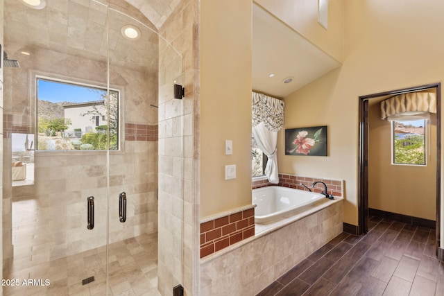 bathroom featuring a garden tub, a stall shower, and a wealth of natural light