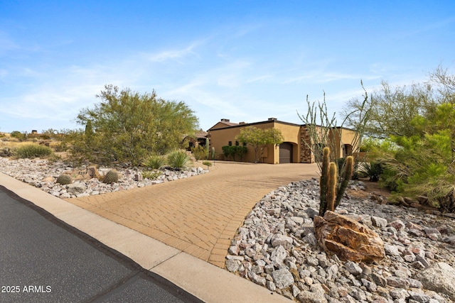 view of front of property featuring an attached garage, driveway, and stucco siding