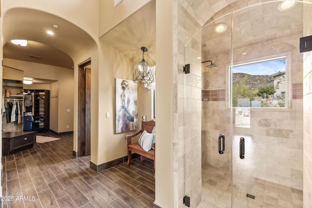 bathroom with baseboards, ensuite bathroom, a shower stall, and visible vents