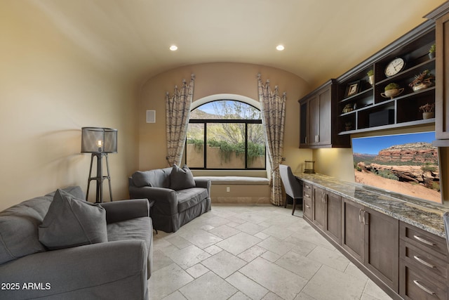 interior space featuring recessed lighting, baseboards, built in desk, and stone tile flooring