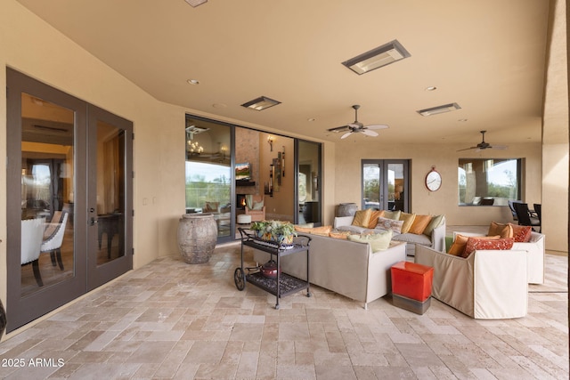 living room with french doors, recessed lighting, ceiling fan, and stone tile flooring
