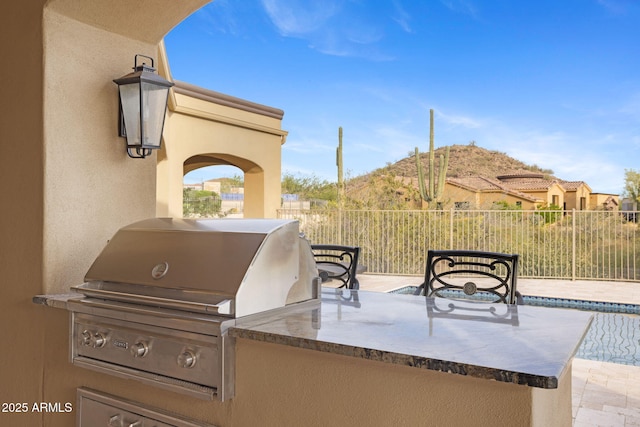 view of patio / terrace with fence, exterior kitchen, and area for grilling