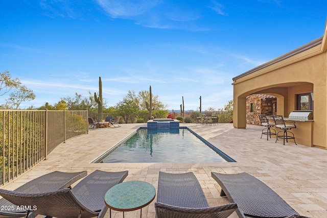 view of swimming pool featuring a pool with connected hot tub, a patio area, outdoor dry bar, fence, and an outdoor fire pit