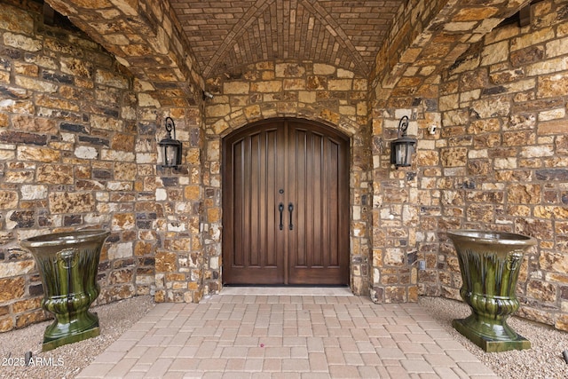 view of exterior entry featuring stone siding