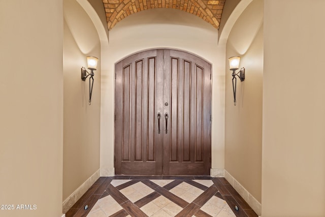 entryway featuring baseboards and arched walkways