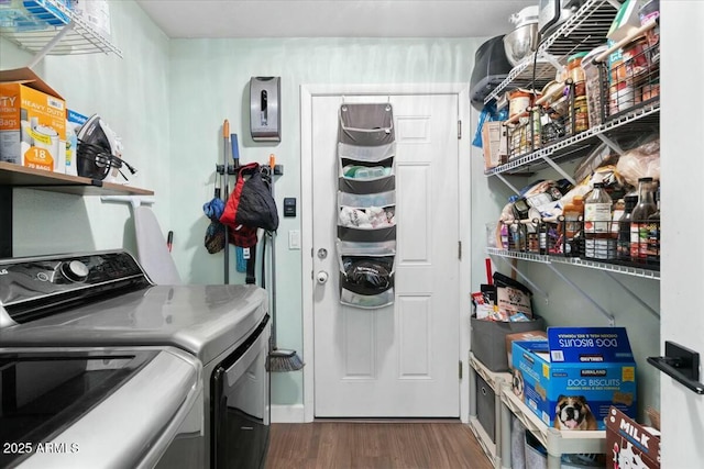 laundry room with washing machine and clothes dryer, laundry area, and dark wood-style floors