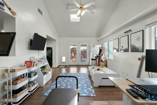 living area featuring visible vents, a ceiling fan, wood finished floors, french doors, and a textured wall