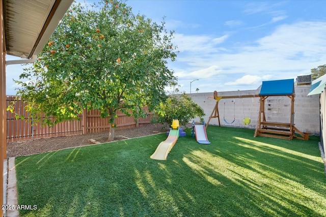 view of yard with a playground and a fenced backyard