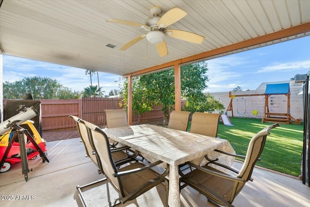 view of patio / terrace featuring visible vents, a ceiling fan, a fenced backyard, a playground, and outdoor dining area