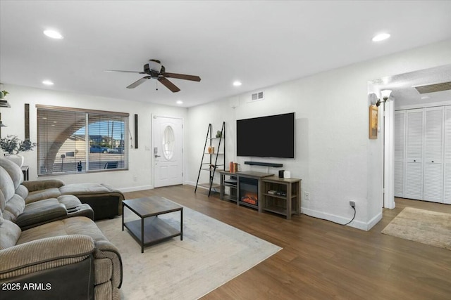 living area with a ceiling fan, recessed lighting, wood finished floors, and visible vents