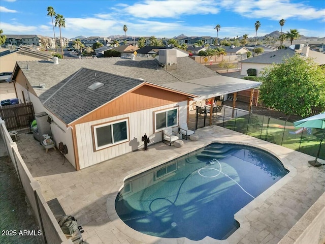 exterior space featuring a residential view, a patio, roof with shingles, and a fenced backyard