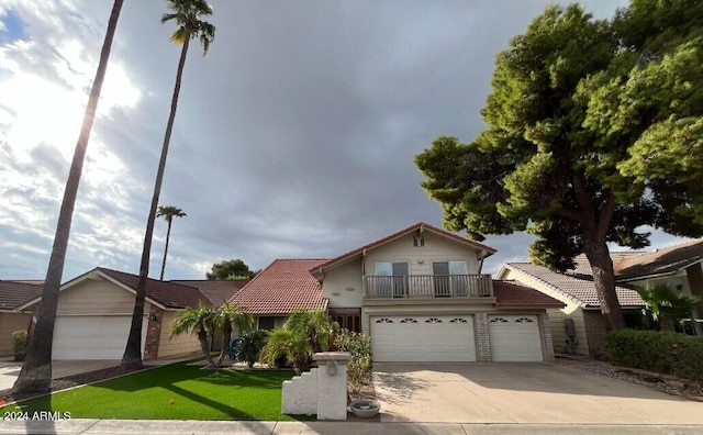 view of front property with a front yard, a balcony, and a garage