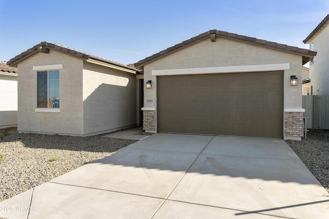 view of front of house with a garage, concrete driveway, a tiled roof, and stucco siding