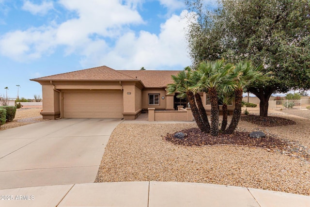 view of front of property featuring a garage, concrete driveway, and stucco siding