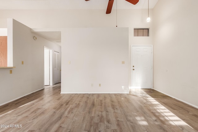 empty room with a high ceiling and light hardwood / wood-style floors