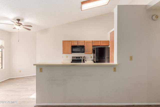 kitchen with lofted ceiling, black appliances, light hardwood / wood-style flooring, ceiling fan, and kitchen peninsula