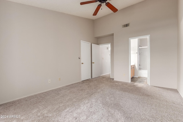 unfurnished bedroom with a closet, ceiling fan, ensuite bathroom, and light carpet