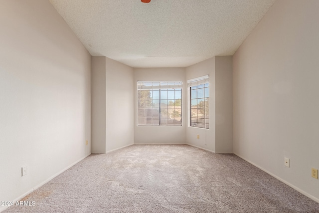 empty room with a textured ceiling and carpet floors