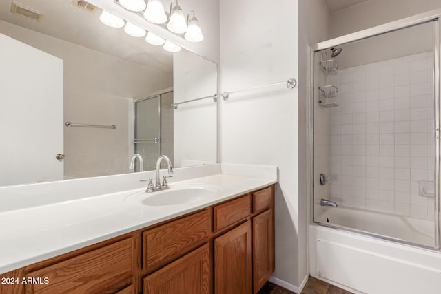 bathroom featuring combined bath / shower with glass door and vanity