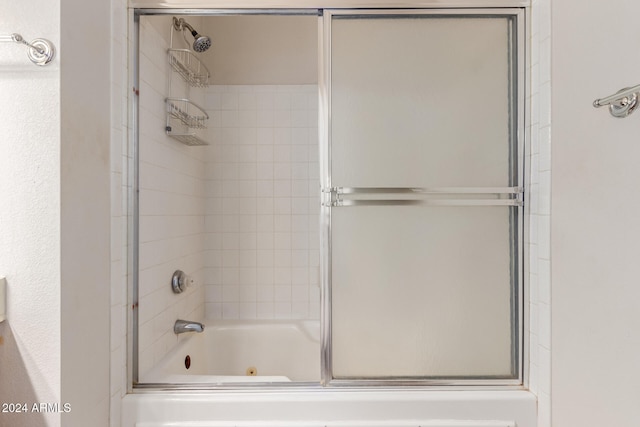 bathroom with bath / shower combo with glass door