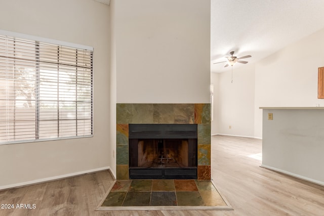 details with a tiled fireplace, ceiling fan, and hardwood / wood-style flooring