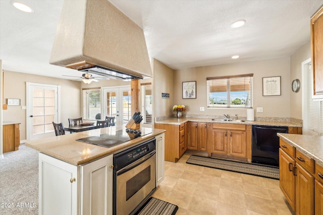 kitchen with a sink, french doors, a wealth of natural light, black appliances, and custom range hood