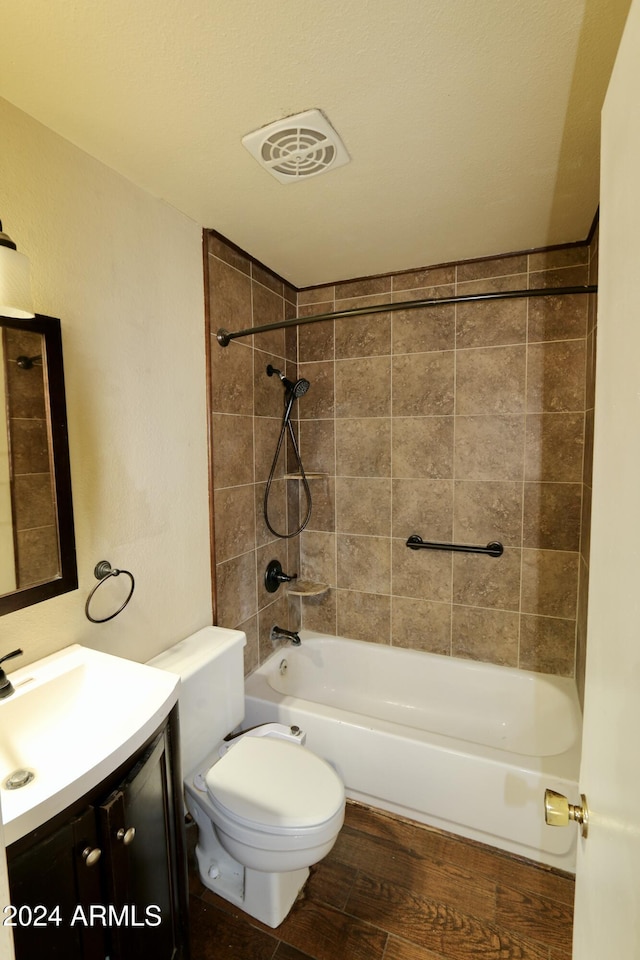 full bathroom with vanity, a textured ceiling, hardwood / wood-style floors, toilet, and tiled shower / bath