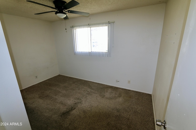 unfurnished room featuring dark colored carpet, ceiling fan, and a textured ceiling