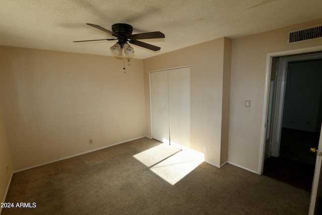 unfurnished bedroom with ceiling fan, a closet, carpet, and a textured ceiling