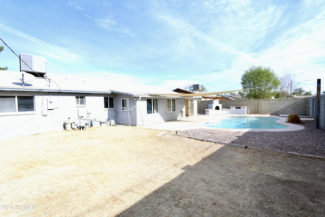 rear view of house with a patio area, a fenced in pool, and cooling unit